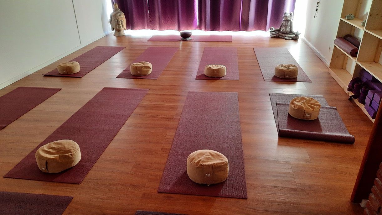 Yogaraum mit Matten und Meditationskissen